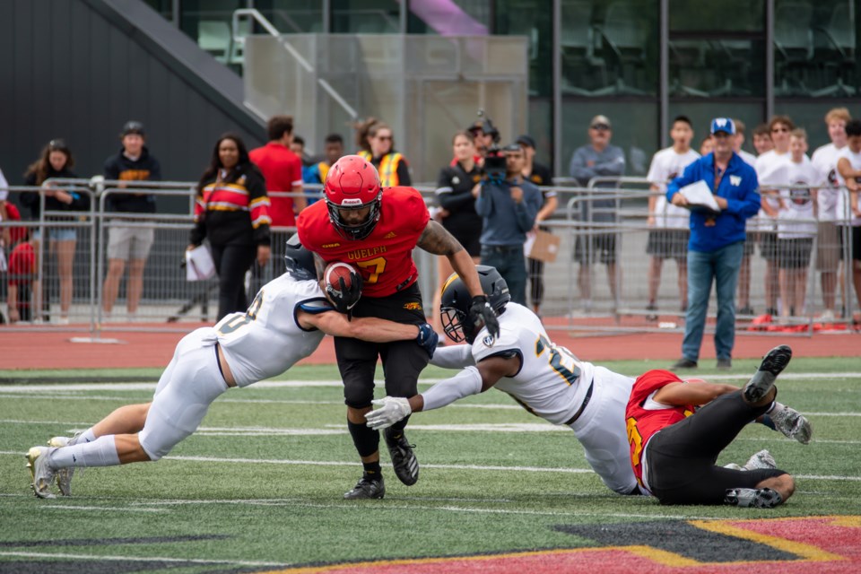 Kaine Stevenson (7) of the Guelph Gryphons tries to run between a pair of Windsor Lancers on a punt return during Monday's OUA football game at Alumni Stadium. The visiting Lancers posted a 28-24 victory.