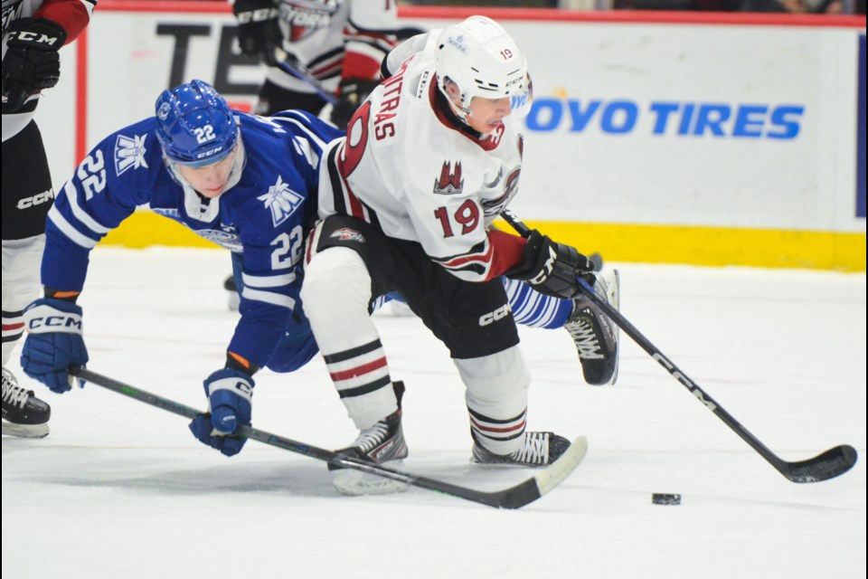 Guelph's Matt Poitras shields the puck from Mississauga's Kasper Larsen during OHL action at the Sleeman Centre Friday.