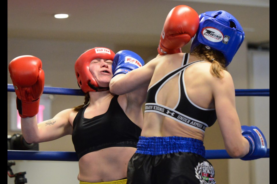 Emily Verbeek, in blue, from Sudbury MMA connects on Calista Sulkye of Golden TIger during a live kickboxing event Sunday afternoon at the Royal Canadian Legion that attracted around 250 people.
