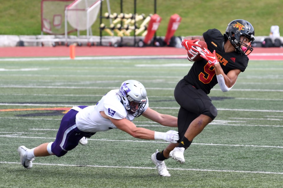 Receiver Jordan Terrio, right, of the Guelph Gryphons tries to break away from a diving Devin Comber of the Western Mustangs during OUA football play Saturday at Alumni Stadium.  Rob Massey for GuelphToday