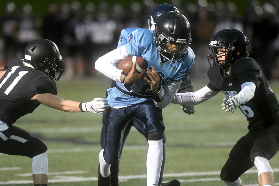 Quarterback Niko Jean-Gaston (12) of the Ross Royals carries the ball between defenders Jack Weiler (11) and Rueben Branco (16) of the St. James Lions Friday night during District 10 high school football's championship match at Alumni Stadium. Ross won 34-9. Rob Massey for GuelphToday