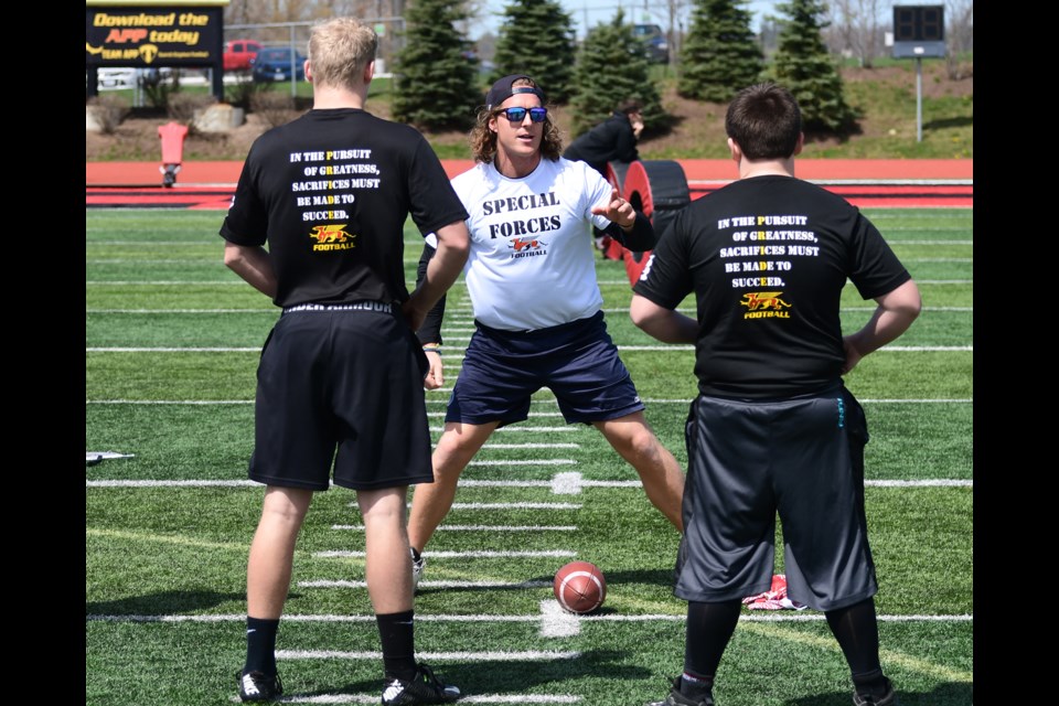 Jake Reinhart, centre, of the Toronto Argonauts gives pointers to a pair of participants in a Guelph Gryphons football camp at Alumni Stadium in 2016. Reinhart is back at Alumni Stadium for the Argos training camp. Rob Massey photo