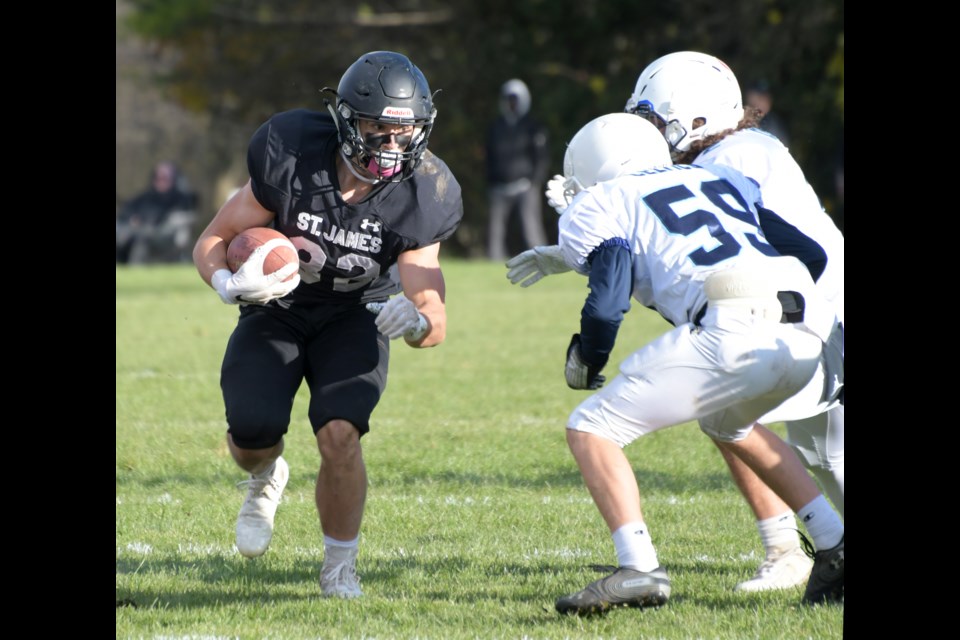 Ben Cottrell, left, of the St. James Lions stares at a couple of opponents from the Bishop Macdonell Celtics during last week's District 10 high school football semifinal match at the Guelph Lake Sports Fields. The Lions advanced to get a berth in this week's championship game.