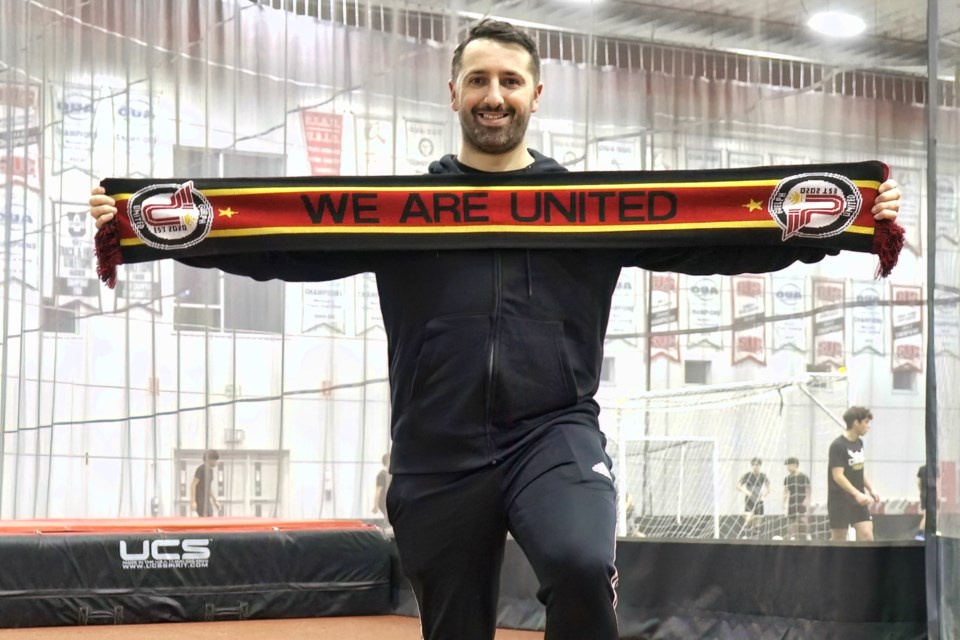 Randy Ribeiro stretches a Guelph United FC scarf after being named head coach of GUFC's League1 Ontario Women's Premier League team's head coach.  He served as the head coach of Peterborough's Electric City FC's L1O's men's and women's teams the past two seasons.