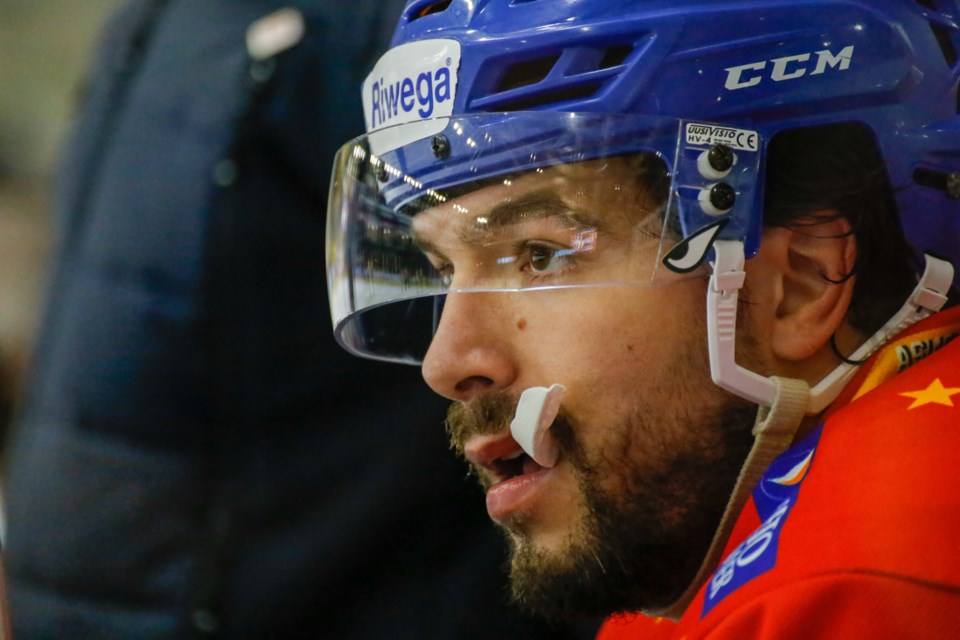 Guelph's Giordano Finoro of HC Asiago chews on his mouthguard as he sits on the bench watching play in the ICE Hockey League this season. Finoro is in his third season with the Italian team.