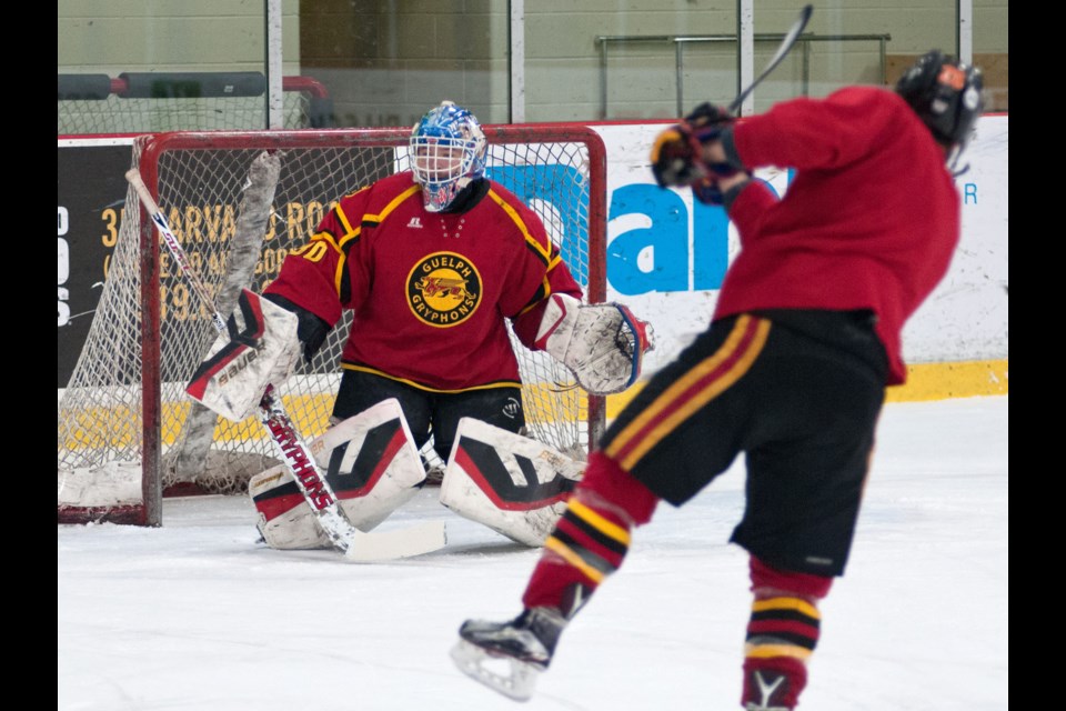 Goaltender Scott Stajcer of the Guelph Gryphons gets his blocker up to stop a shot by Carlos Amestoy during Tuesday's practice at the Gryphon Centre.