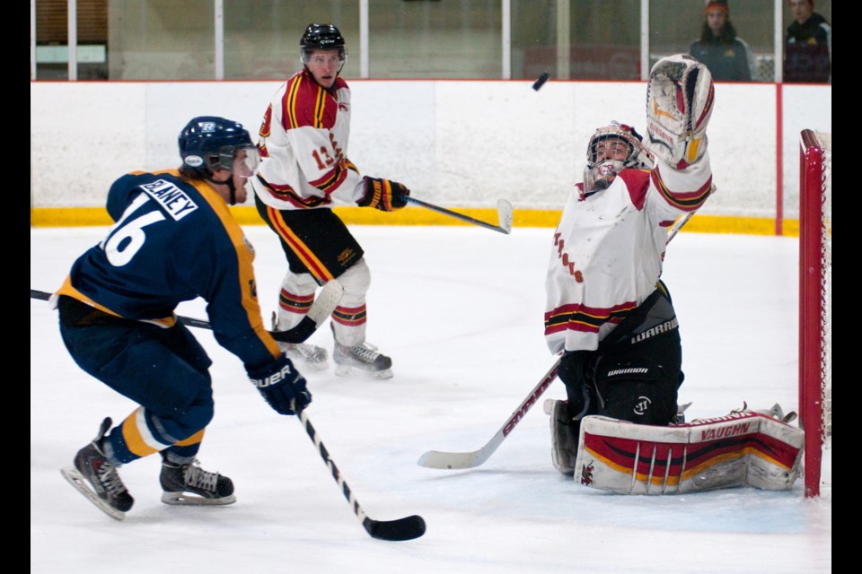 Goaltender Andrew D'Agostini of the Guelph Gryphons reaches up to grab a shot by Kyle Blaney (16) of the Ryerson Rams during OUA men's hockey playoff action Thursday night at the Gryphon Centre. The Gryphs won the series opener 5-3. Rob Massey for GuelphToday