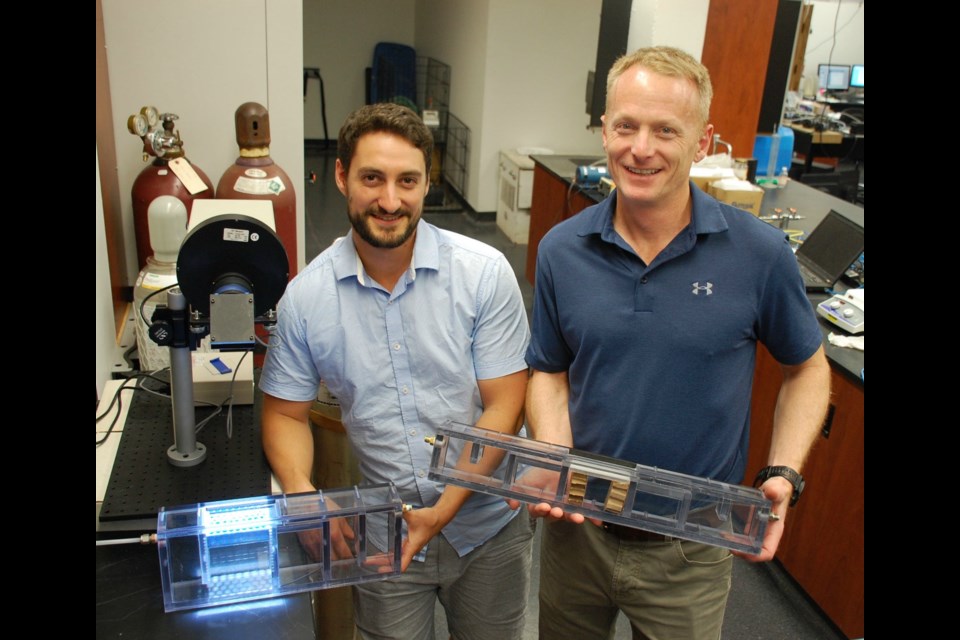 David Wood (left) and Bill Van Heyst are pictured in their University of Guelph lab with two SmogStop prototypes. Photo by Alaina Osborne/SPARK.