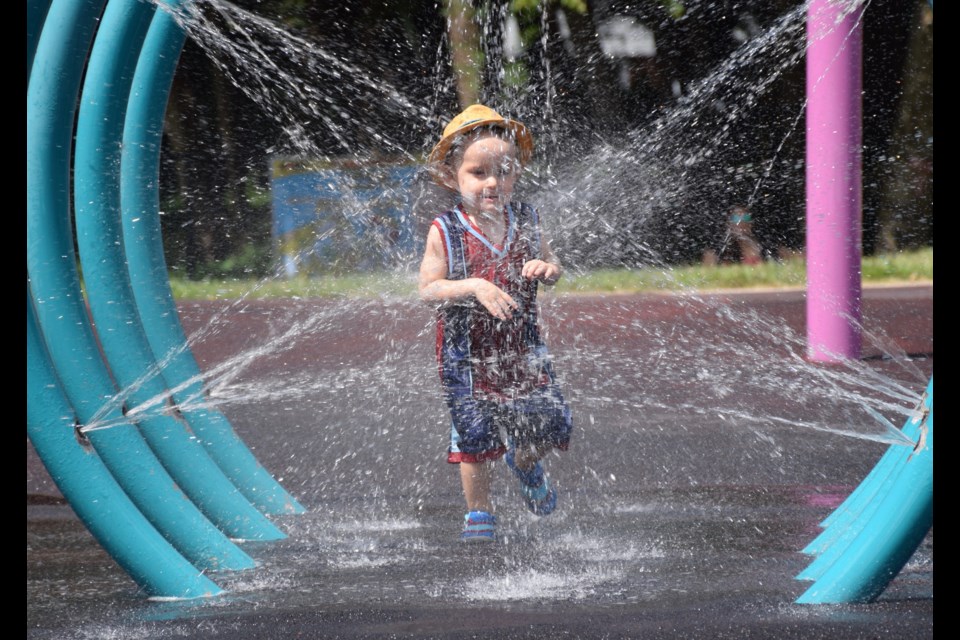 A boy finds cooling spray at Norm Jary Park on Friday. 