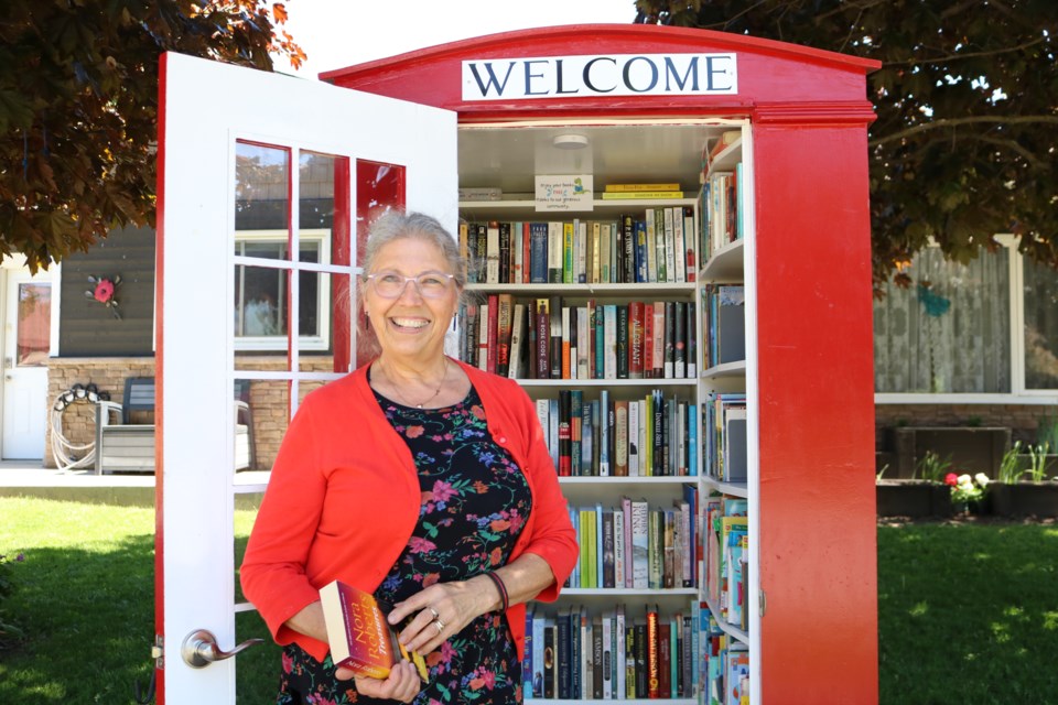 Drayton, Ont. resident Glynis Belec stands in front of her Little Red Library.