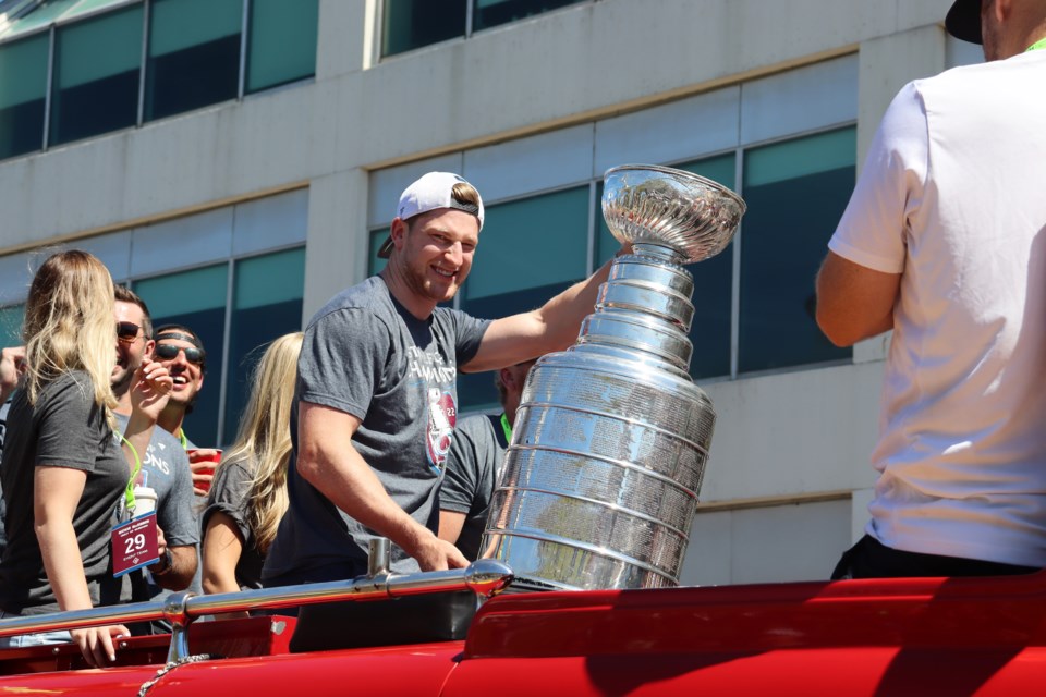 mackinnon looks on while holding cup