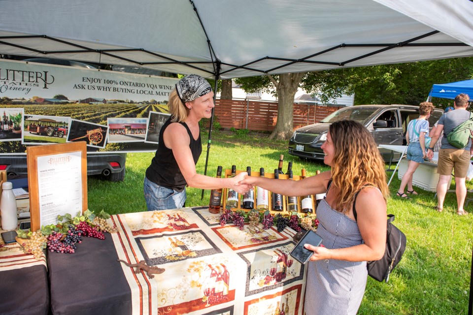 Kirstin Smith from Pillitteri Estates Winery greets customer Tammy Oliveira at the first Acton Outdoor Market, now running at Prospect Park every Thursday from 4 to 7 p.m.