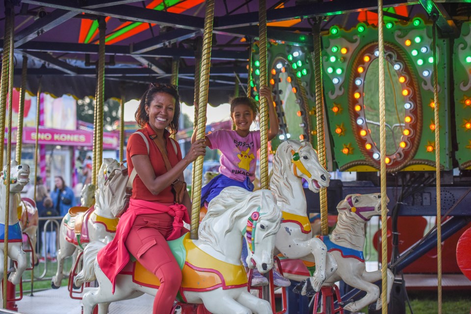 Barbara and daughter Bianka enjoy the merry go-round at the Acton Fall Fair.