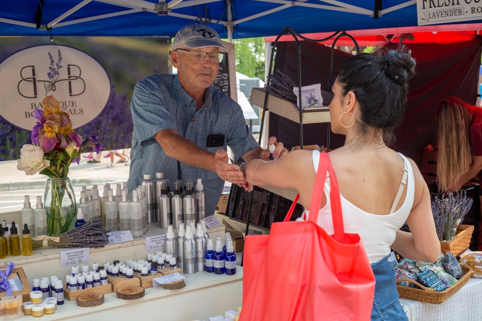 Baroque Botanicals Lavender owner Tom Herdes helps one of his customers test a scent at the Georgetown Farmers' Market Saturday morning.