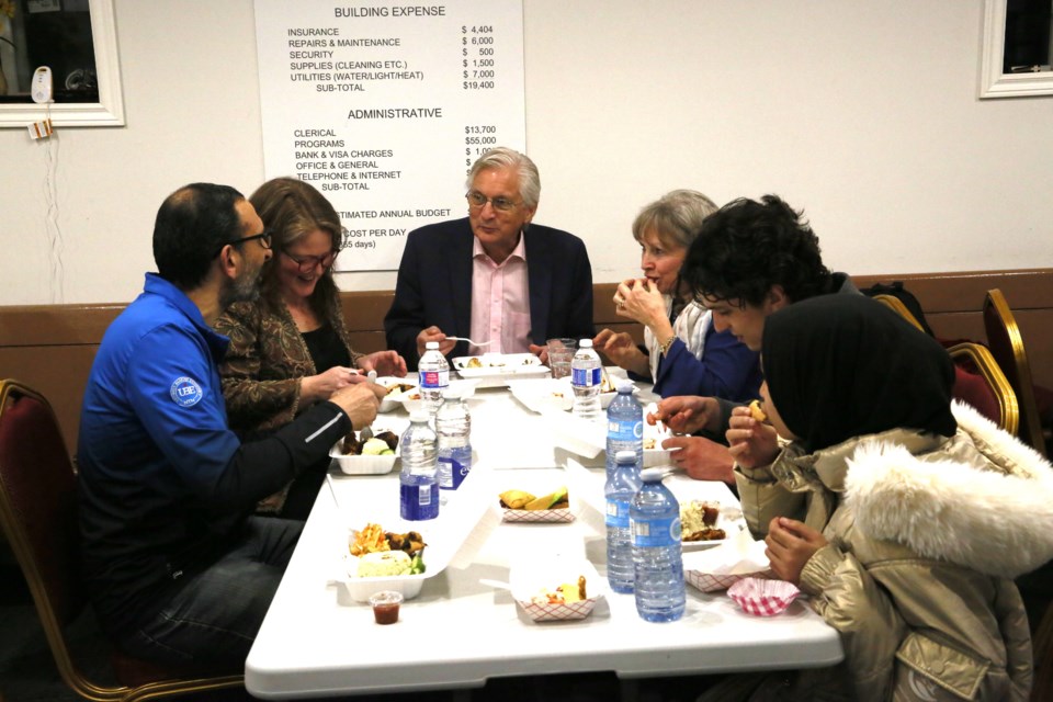 Former Norval United Church minister Paul Ivany (centre) and Councillor Chantal Garneau (left) join others to enjoy an Indonesian meal as part of the iftar dinner.