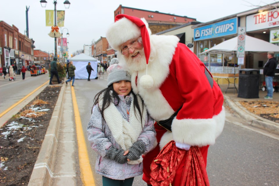 Mia Arias enjoys a moment with Santa at the Downtown Georgetown Holiday Market, which took over the downtown core with plenty of festive fun Saturday.