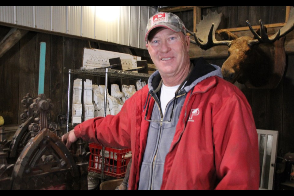 Ted Finch of PDI National Salvage leans on a 1773 Oddfellows chair in his shop in Bradford. After a fire gutted an apartment in Bradford, PDI made a large donation to keep a couple warm for the winter. 