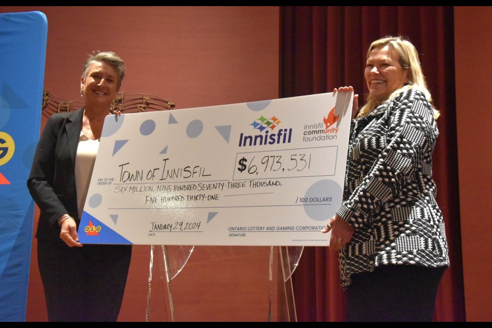OLG senior municipal relations manager Kathleen Devine, left, and Innisfil Mayor Lynn Dollin hold a novelty cheque representing the more than $6.97 million paid to the town during the last fiscal year for hosting Gateway Casinos.  