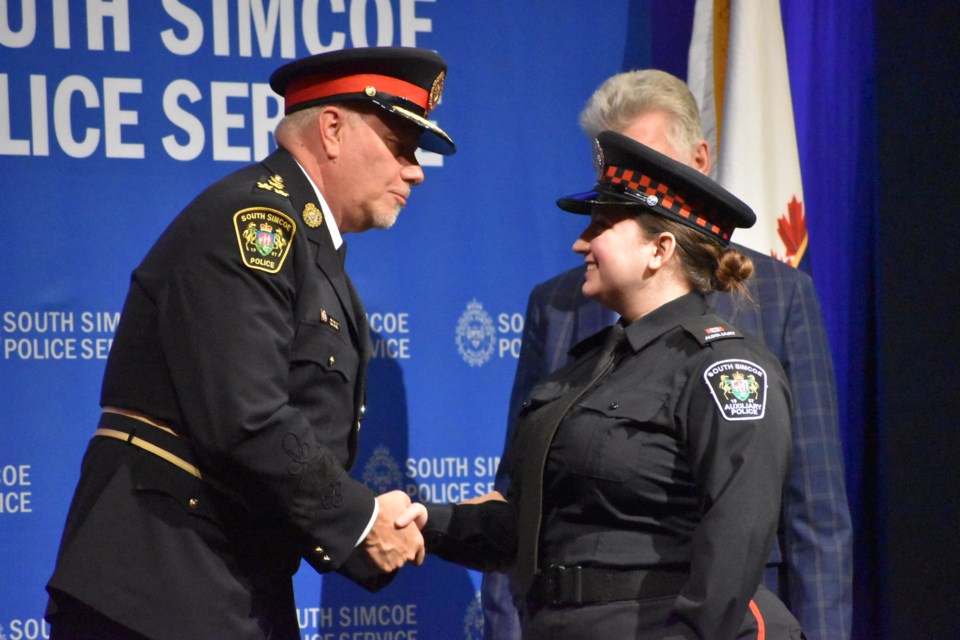 South Simcoe Police Service auxiliary officer Alexya Machado received the Auxiliary Officer of the Year Award and shook hands with Chief John Van Dyke.