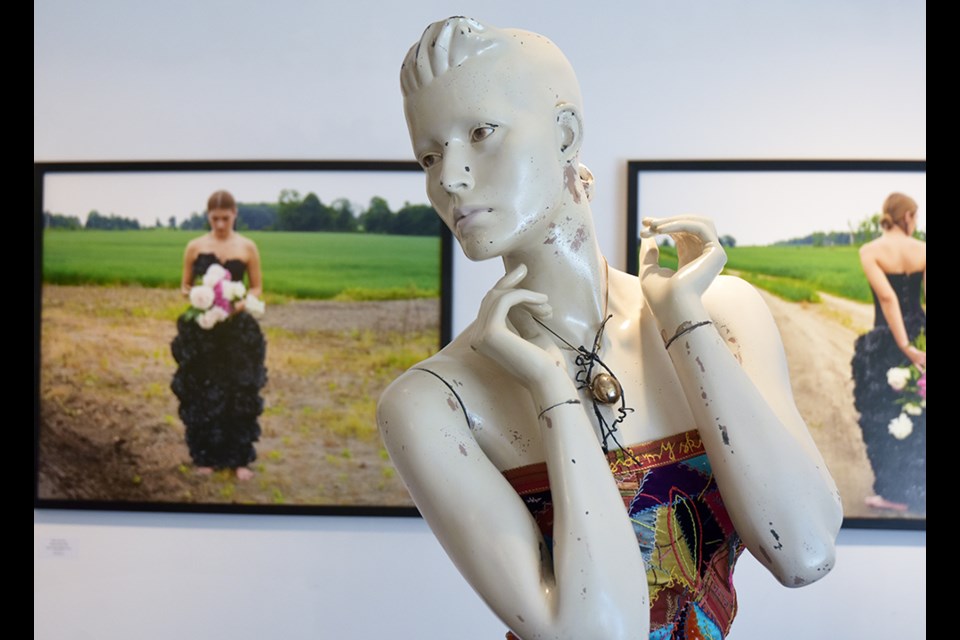 Enigmatic white mannikin, in Crazy quilt dress by Marlene Hilton Moore, at be contemporary art gallery. 