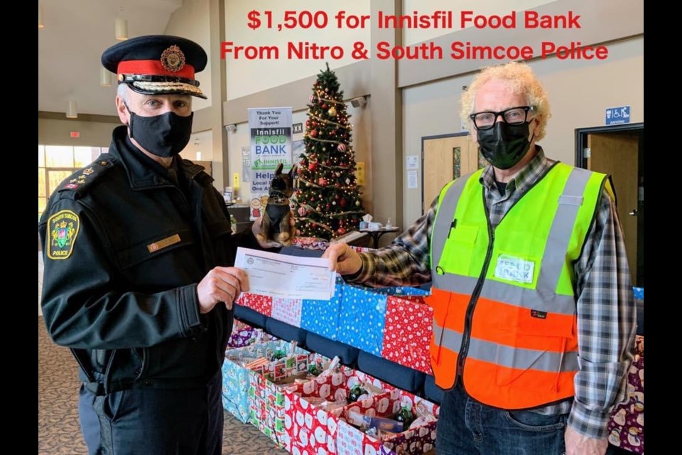 Chief Andrew Fletcher drops off a $1.500 cheque for the Innisfil Food Bank 