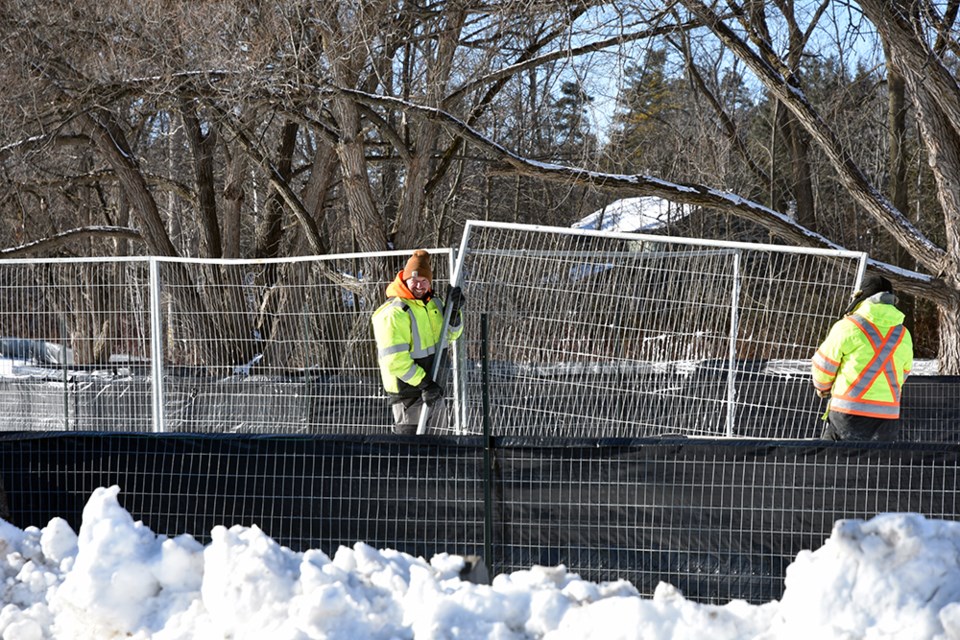Despite frigid temperatures, workers were out setting up construction fencing in the park.
