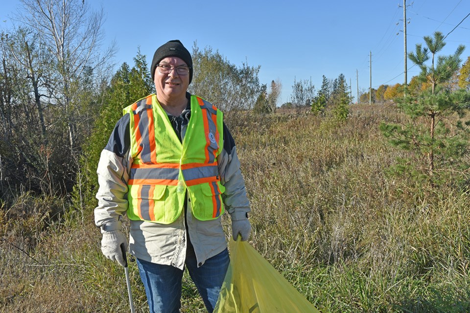 Leslie Pollak, picking up litter along  Sideroad 20, in another Clean Up day. 