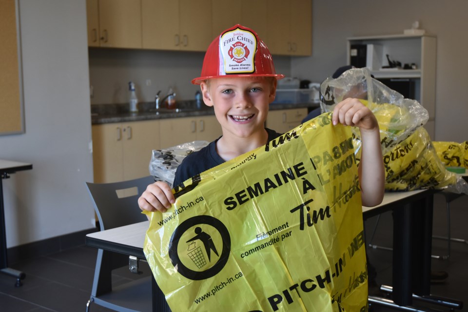 Colby, 8, with Pitch In Day garbage bag, at the Lefroy Fire Station. 