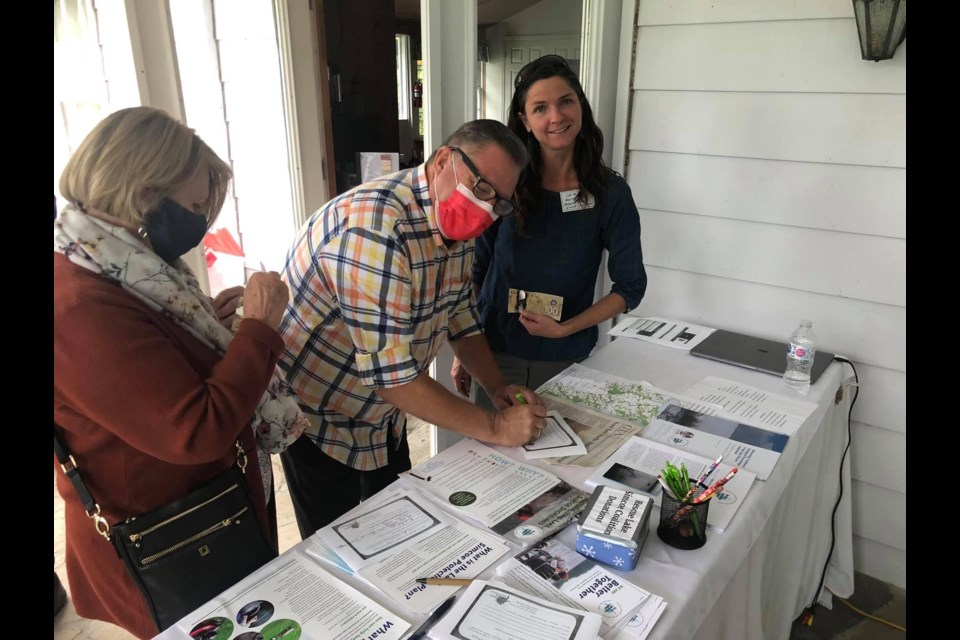 Executive Director for the Rescue Lake Simcoe Coalition, Claire Malcolmson at the donation table with guests of the Rescue Lake Simcoe event held on Oct 3/2021 at Big Bay Point Golf Course