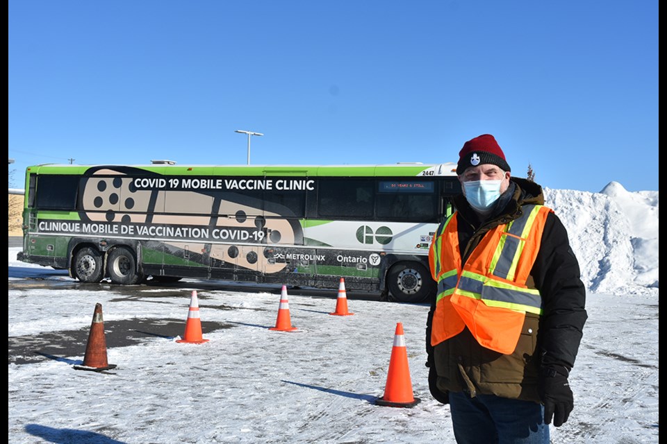 Paul Jackson helps direct members of the public to the Mobile Vaccine Clinic in the Alcona Canadian Tire Store parking lot on Jan. 23.