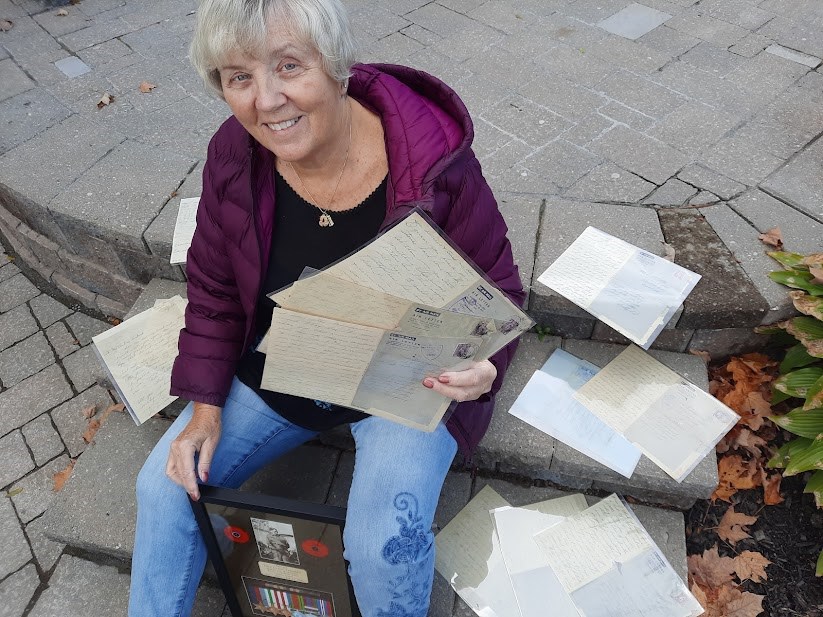 Barrie resident Eleanor McCue with the letters written by her father and mother during the Second World War, as well as the memorial plaque of her father's medals.