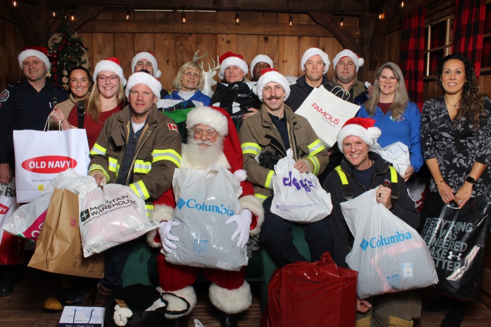 The Hometown Heroes, volunteers of C4Kids, and the team at Tanger Outlets in Cookstown pose for a photo with Santa Claus. 