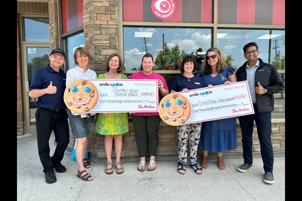 Tim Hortons store manager Darren Boyle (left), CEO of Essa Public Library Laura Wark, library board chair Judith Hunter, Holly Elliott, coordinator of children, library board chair Anne Smith, CEO of Innisfil ideaLAB & Library Erin Scuccimarri, and Tanger Outlets, Cookstown Tim Hortons general manager Rajat Gupta together for Smile Cookie cheque presentation