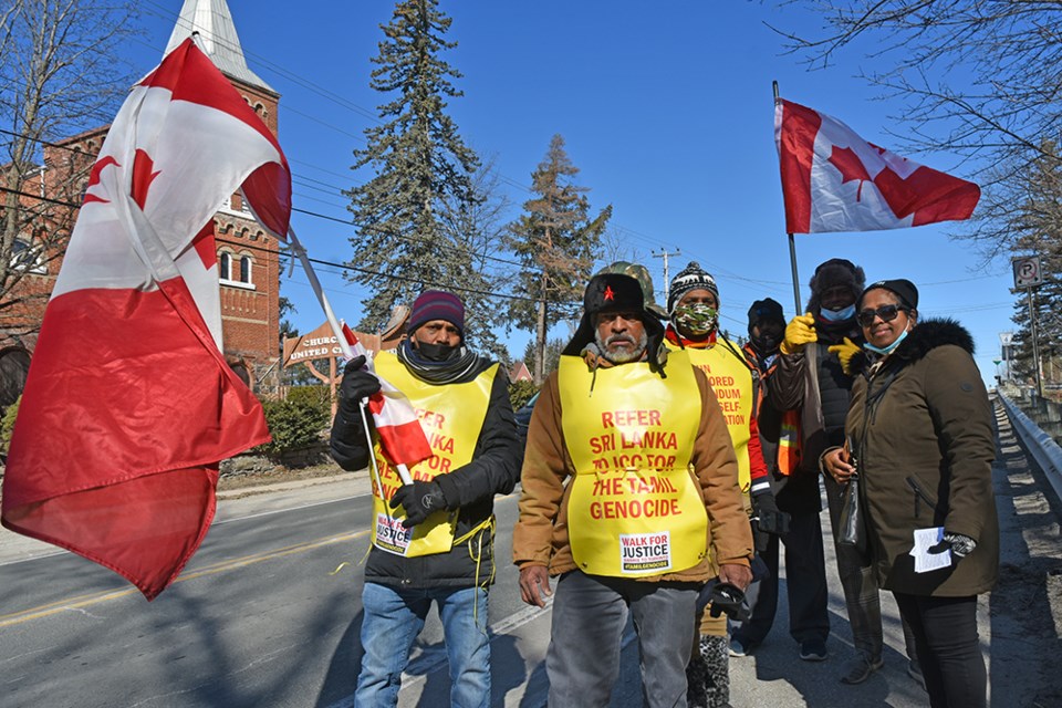 A group of six walkers pause in Churchill, Innisfil, on their Walk for Justice for the Tamil people. 