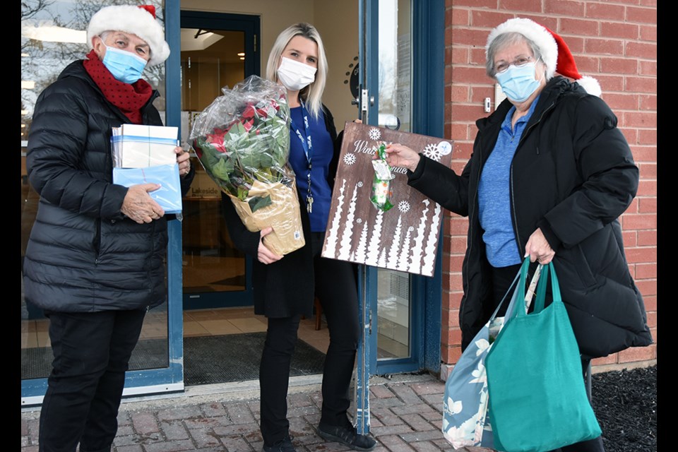 Lakeside Retirement's Chanelle Perdue (centre) accepts gifts and cards from Senior Wish Association reps Sharon Wice, left, and Elizabeth Brandon.