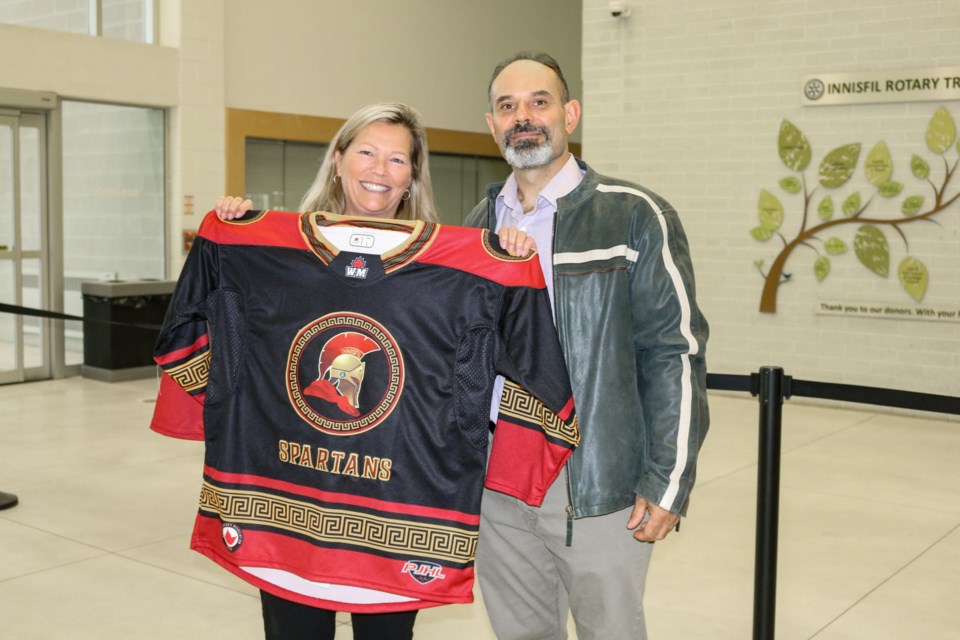 Mayor Lynn Dollin and Spartans owner George Floros hold up the team's jersey prior to the team's inaugural game on home ice.