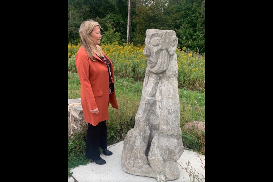 Mayor Lynn Dollin is shown on the Rotary Trail with the statue called Mann.