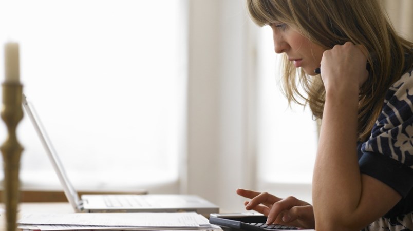 self-employed-woman-working-from-home-with-laptop-calculator