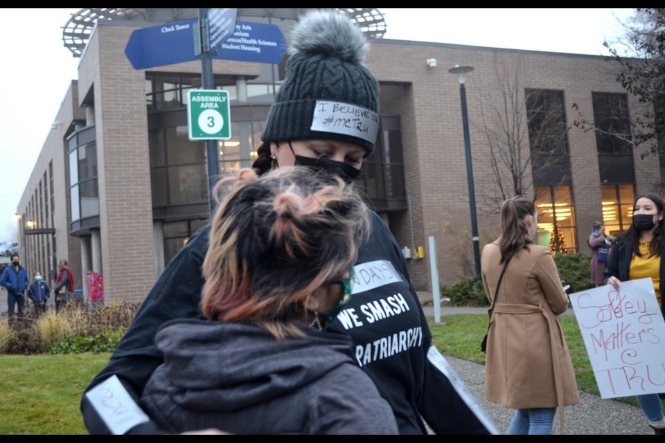 Two people embrace ahead of a march organized at TRU to protest the handling of an investigation into the misconduct of two senior officials.