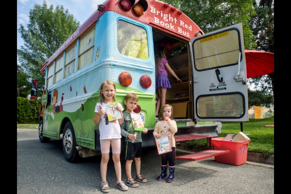 Among those taking books home this summer were siblings Ella (left), Caleb and Lauren Suzuki. For more information on the program, go online to facebook.com/BrightRedBookBus.
