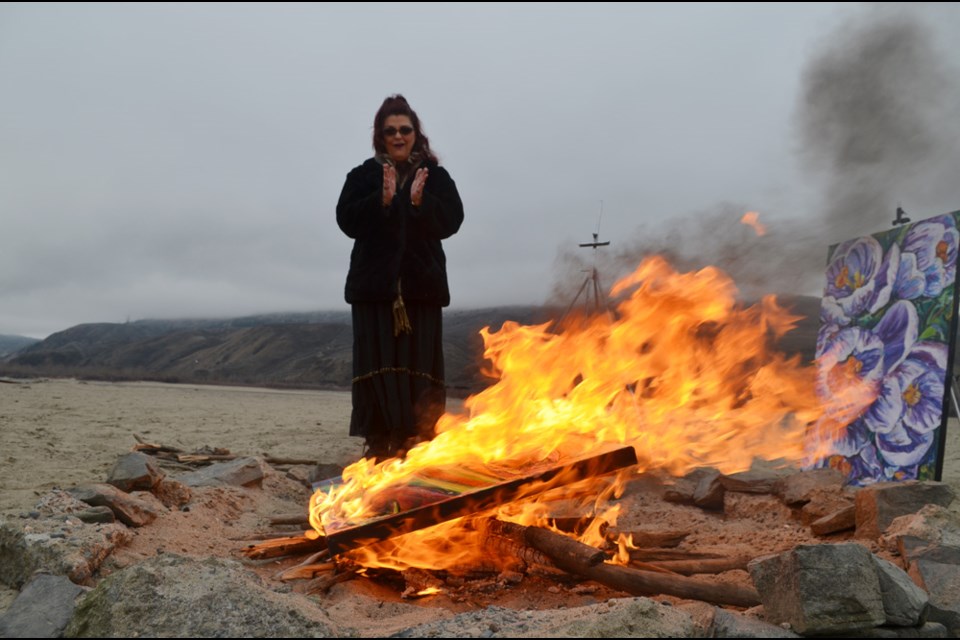 Karla Pearce  watches one of her paintings go up in flames on March 18, 2022.