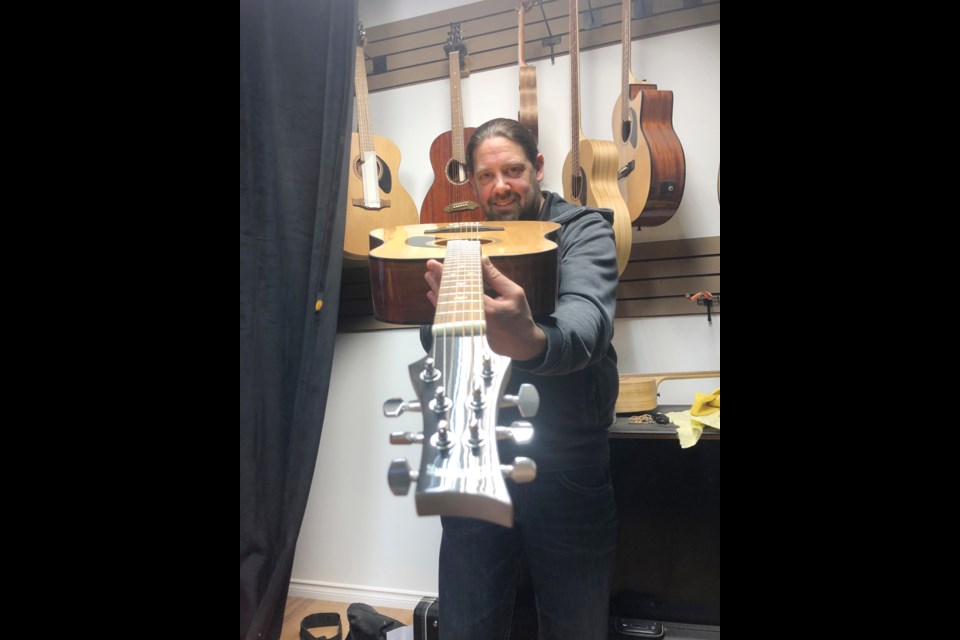 Mike Miltimore of Riversong Guitars and Lee’s Music with the Riversong Pacfiic series P-550 guitar that will be handed over to the person who delivers to him the Mayor’s Chain of Office.
