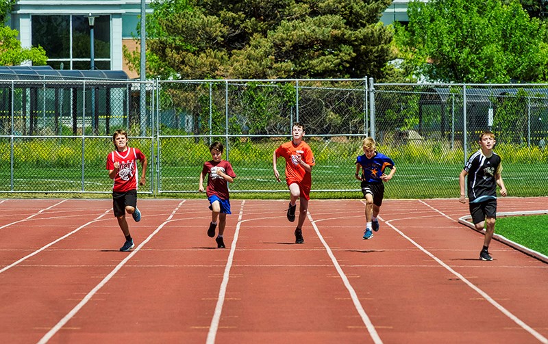 A field of runners take the last corner for the final stretch in the boy's 300 metre run on May 31, 2023, during the District Elementary Track and Field Championships  at Hillside Stadium.