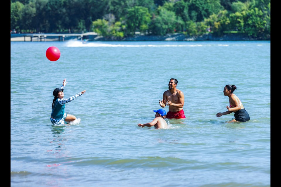A family keeps cool while playing in the Thompson River at Overlanders Beach in North Kamloops.