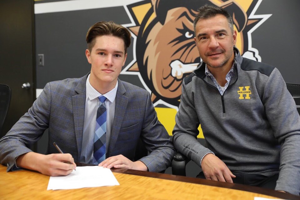 Chandler Romeo signing with the Hamilton Bulldogs Photo from @chandleromeo on Twitter
