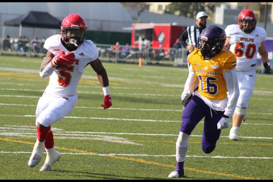 Laurier's Will Amoah chases down Guelph running back Juwan Jeffrey.