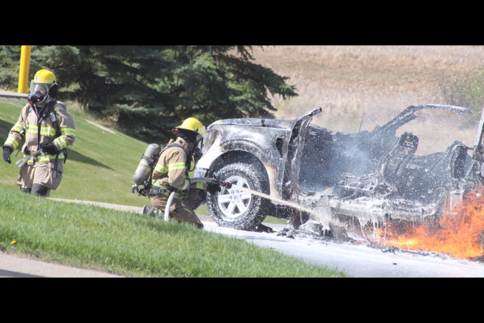 Firefighters with Lac La Biche County Fire Rescue use foam to extinguish a vehicle fire that took place on 105 Street in the hamlet of Lac La Biche on the morning of May 17 around 11:10 a.m. Chris McGarry photo. 