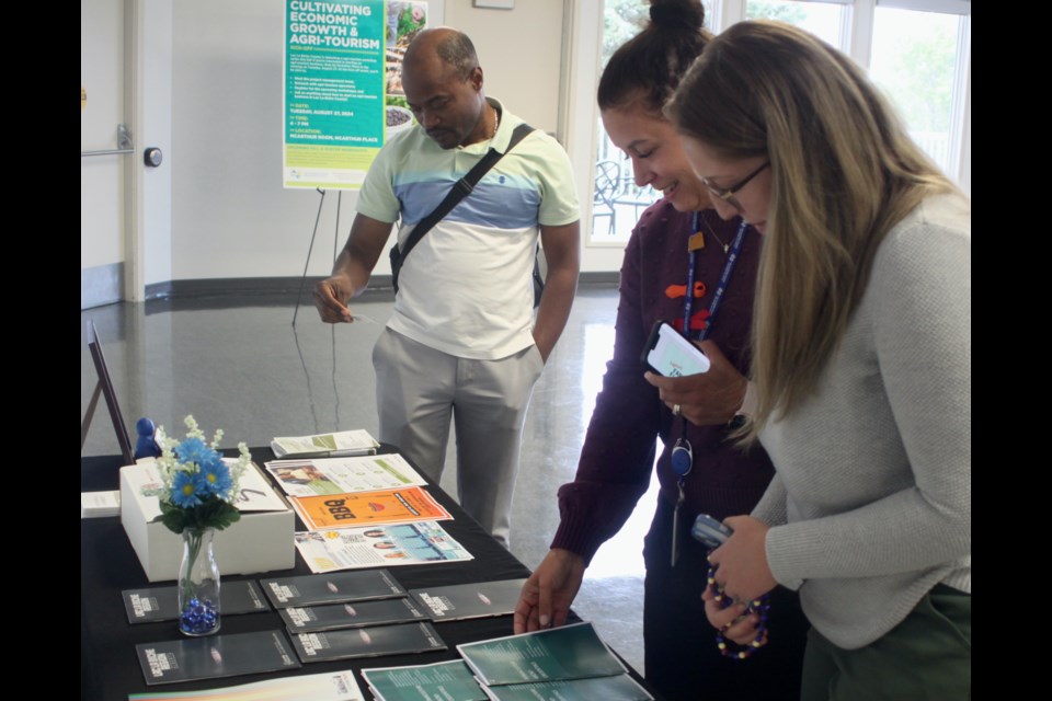 A few of the attendees who came to the kick-off event check out some of the information that was display inside of the McArthur Place community hall. Chris McGarry photo. 