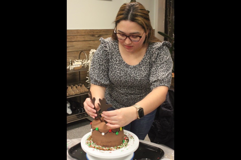 Ana Sandoval puts antlers on her reindeer cake during the decorative workshop that took place at Queen Bean Café and Bakery in Lac La Biche on Friday, Dec. 14. Chris McGarry photo.