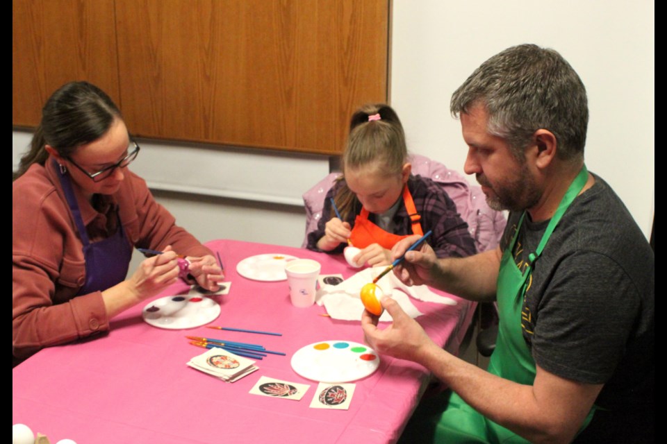Elandra Snook and her parents, Andrew and Ginette, participate in egg-painting at the ‘Spring Traditions’ program which took place at the Lac La Biche Museum on April 5. Chris McGarry photo.
